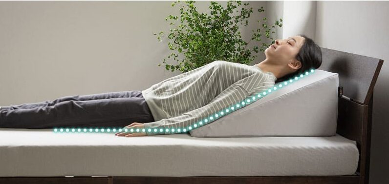 三角枕に寝る女性の画像