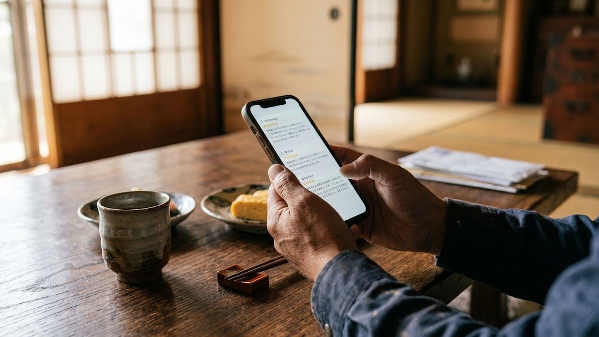 和室のテーブルでスマートフォンの口コミを読む手元